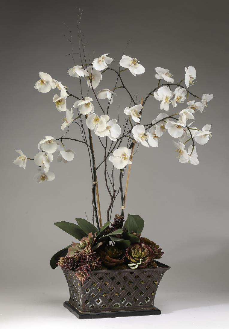 Faux orchid and succulent arrangement, 43"h: Faux orchid and succulent arrangement, having a mature white orchid surrounded by various succulents on a field of moss, all in a flared and pierced metal planter resting on a plinth base, 42.5"h x 28