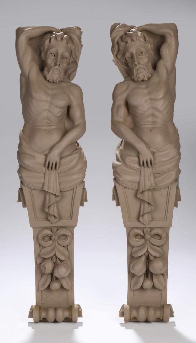 (2) Unfinished cast composition classical pilasters: Pair of unfinished cast composition male term figure pilasters, each depicting a classical male nude with one arm over his head and draped at the waist, above a relief molded swag of fruit, and termin