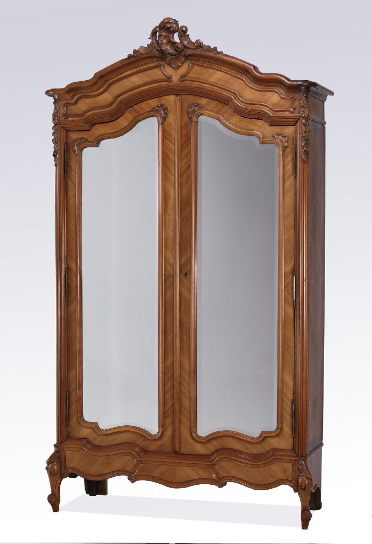 19th c. French walnut armoire by Guerin, Paris, 96"h: 19th century French Rococo Revival walnut armoire by Georges Guerin, Paris, having a pierced rocaille crest above a molded serpentine cornice, surmounting two arched doors with beveled mirrors, openin