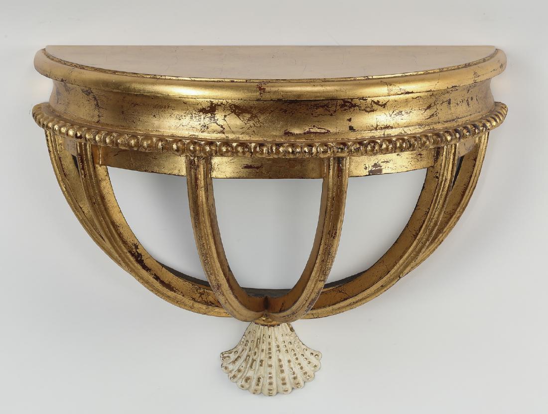 Maitland Smith style giltwood wall bracket, 20"w: Maitland Smith style Regency giltwood wall bracket, having a demi-lune top surmounting a tapering pierced cage terminating to a shell pendant, 15.25"h x 19.25"w x 9.75"d.