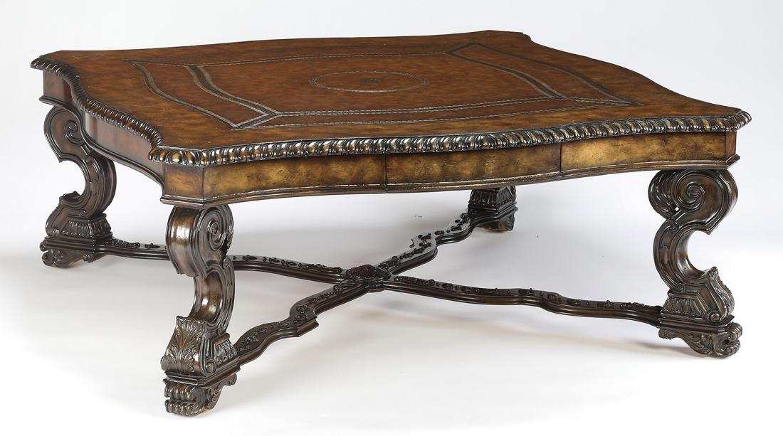 Maitland-Smith carved mahogany & leather coffee table: Maitland-Smith carved mahogany and leather coffee table, having a scalloped surface with canted corners, inlaid with tooled and gilt-decorated leather, resting on an apron with a single drawer, above