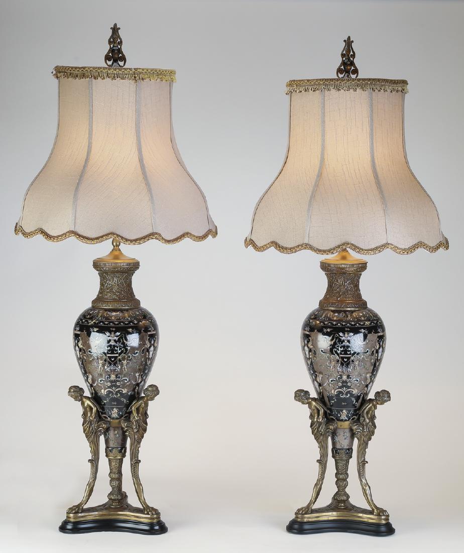 (2) Maitland Smith ceramic & bronze table lamps, 48"h: Pair of Maitland-Smith Empire style ceramic and bronze table lamps, each having a shaped finial above a flared cream linen shade with passementerie trim, above the baluster form ceramic lamp decorated