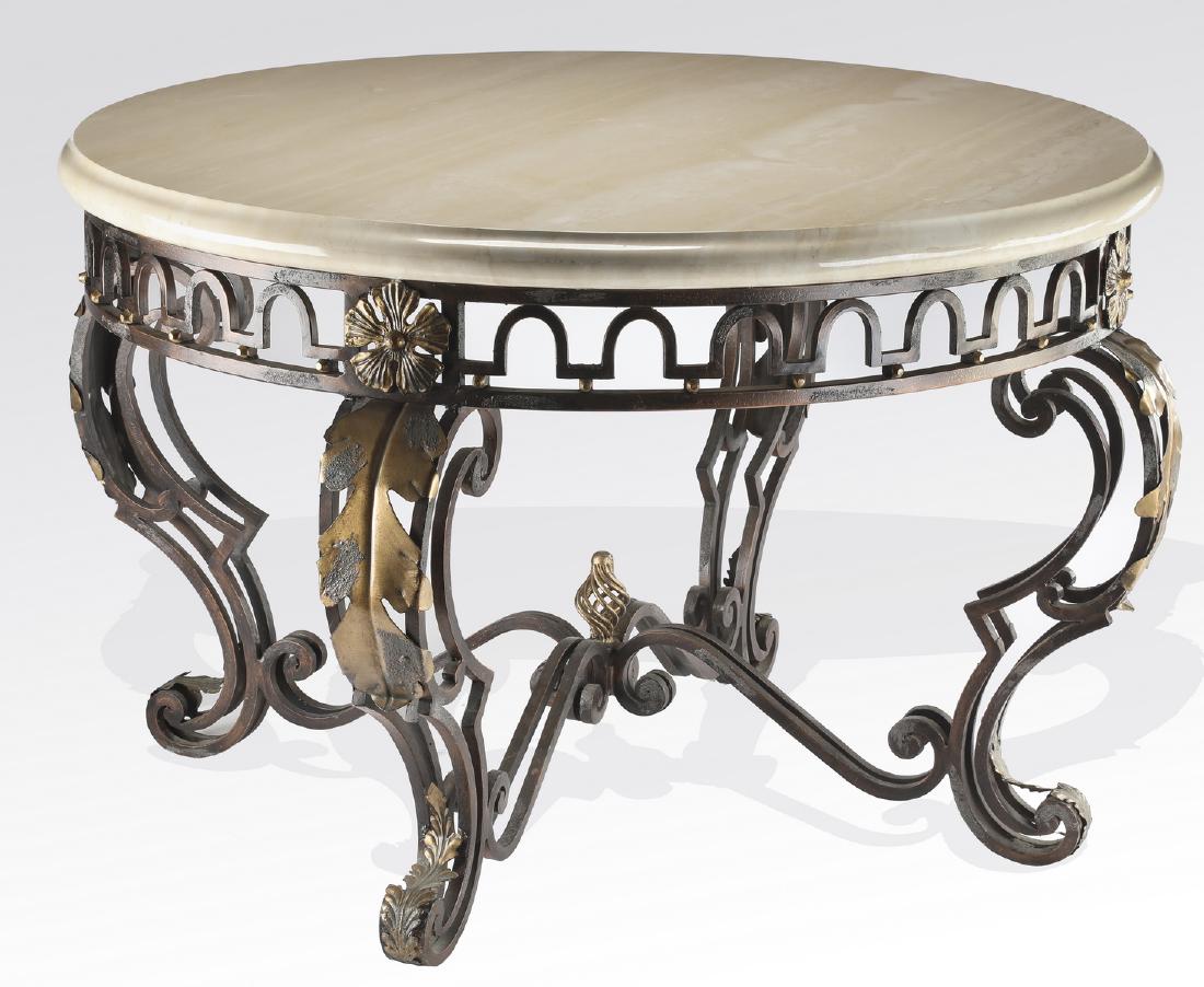 Neoclassical style travertine and iron center table: Neoclassical style travertine center table, having a beveled, circular travertine surface, over an aged metal and iron base, the apron decorated with an arched border accented by foliates, resting on