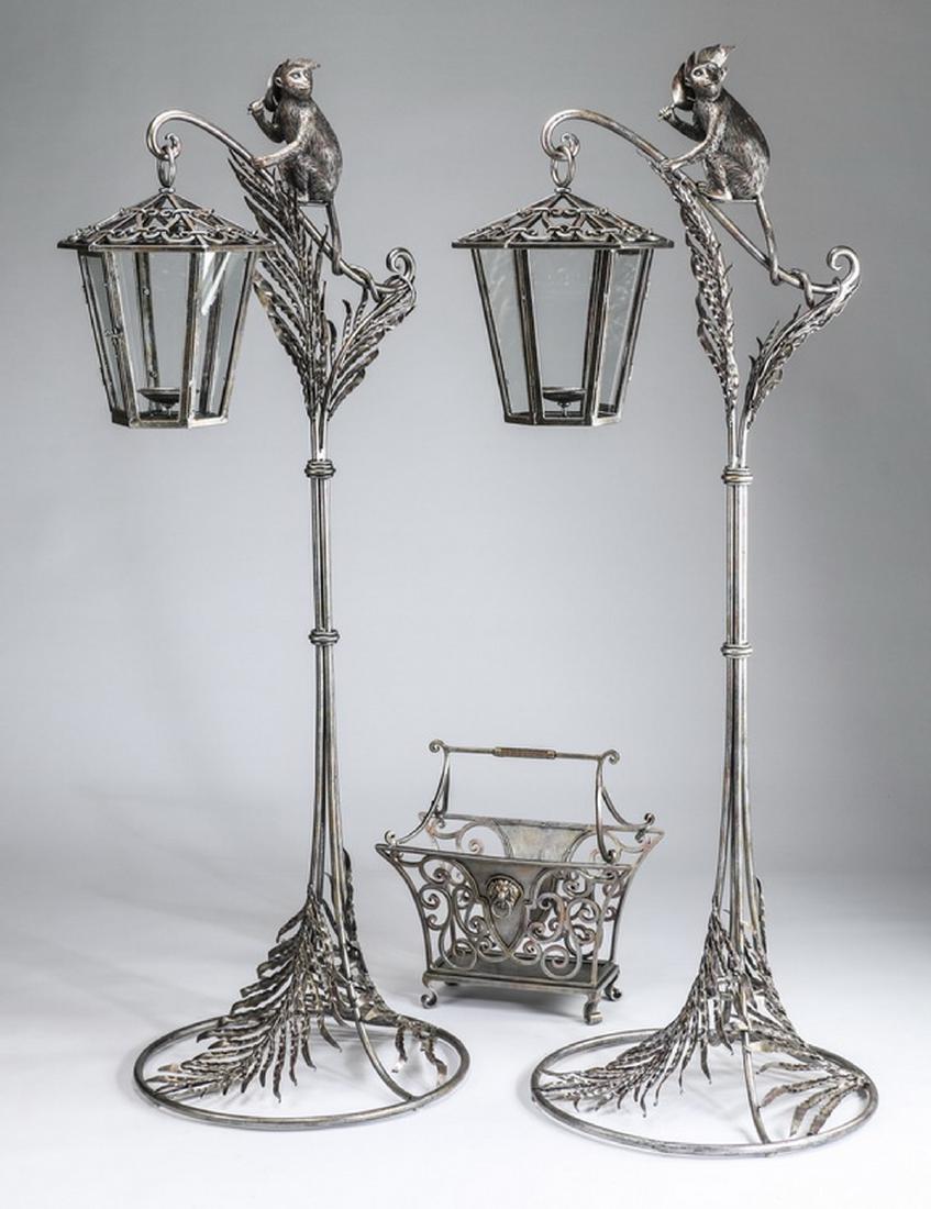 3-Piece grouping: floor lanterns and magazine caddy: Group of three decorative items consisting of a pair of figural floor candle lanterns and a magazine caddy, each made of patinated metal, the freestanding floor lanterns feature a figural monkey sculp