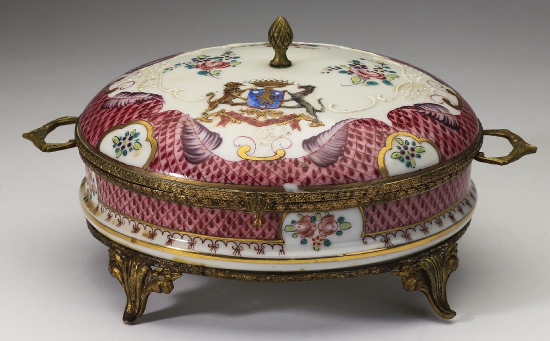 French bronze mounted porcelain armorial style box: French porcelain armorial style handled box, having a bronze acorn finial issuing from the lid decorated with a central armorial crest reading 'Gloria Victa' interspaced with sprays of pink roses and
