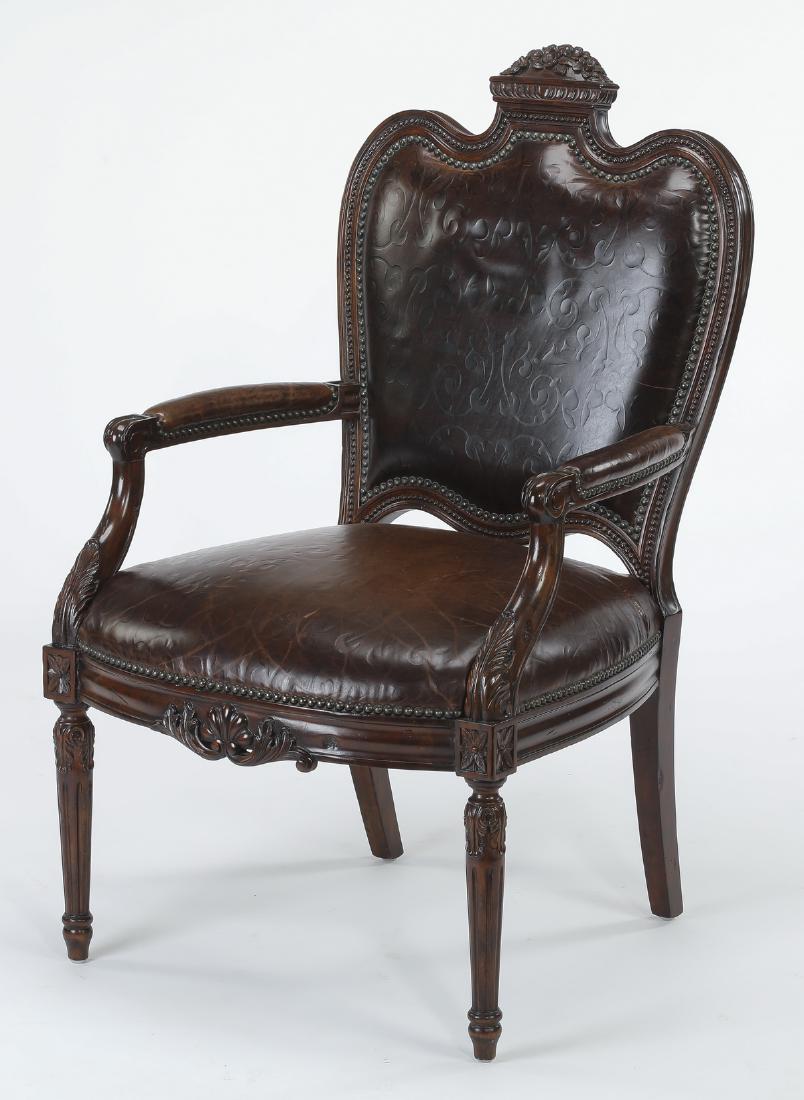 Maitland-Smith embossed leather armchair: Maitland-Smith mahogany and embossed leather armchair, having a carved foliate crest above an arched crest rail, centering the shaped back upholstered in brown embossed scrollwork motif leather with n