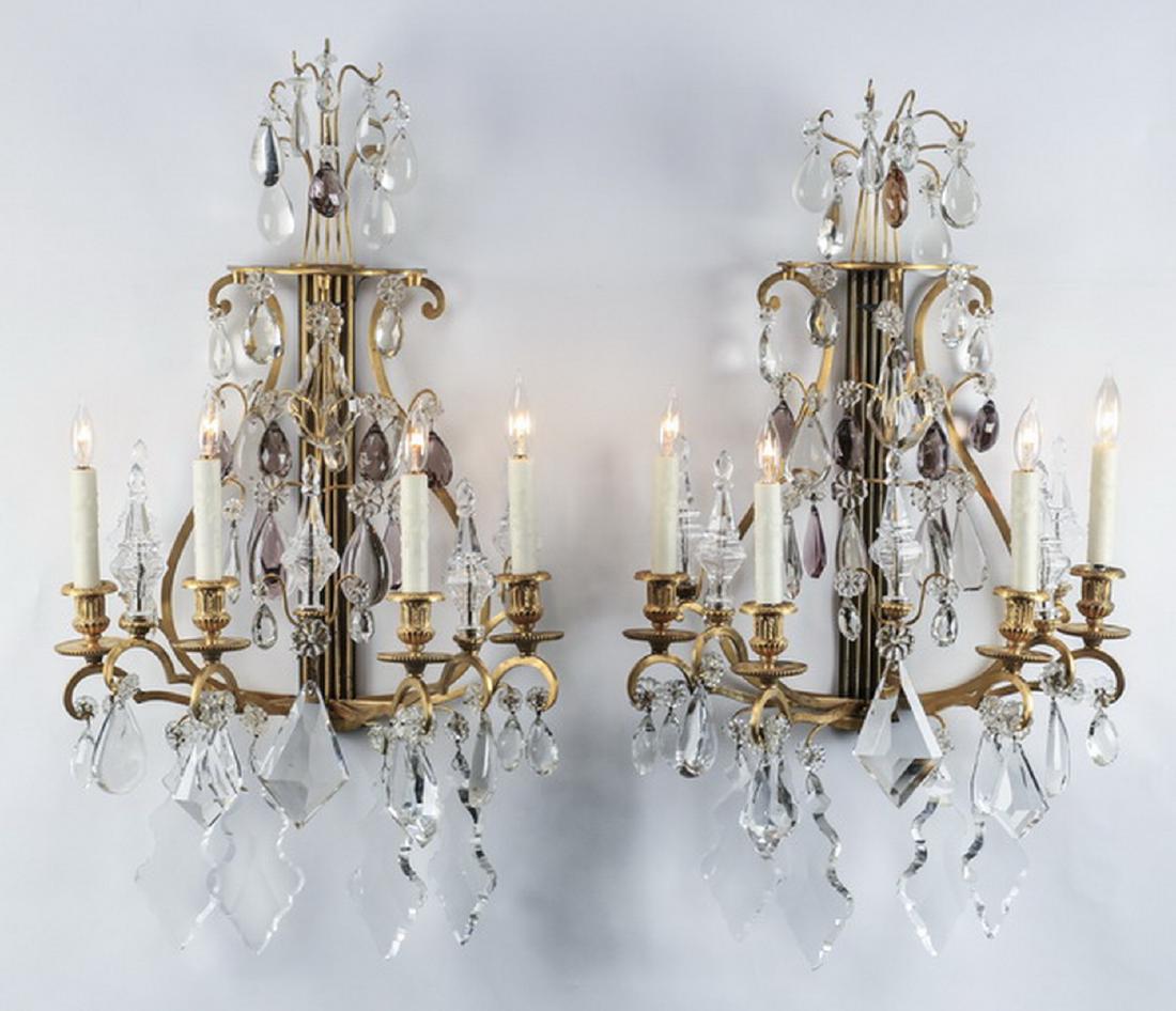 (2) Extravagant French crystal & gilt bronze sconces: Pair of French inspired crystal and gilt bronze wall sconces, each having a ribbed standard with a lyre shaped support for four lights and spires, with clear, light amethyst, and amber pendants, inclu