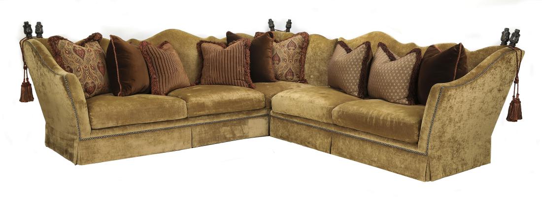 Marge Carson L-shaped sectional w/ accent pillows: Marge Carson L-shaped sectional, in two pieces, having an undulating crest with carved finials and tassels at the corners, with all-over moss upholstery and drop-in seat cushions, all accented with na