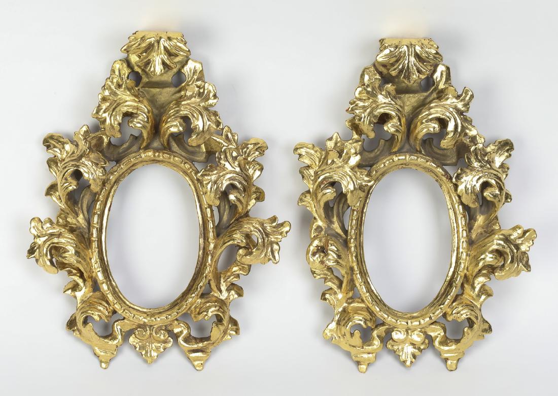 (2) Giltwood frames in the Rococo taste, 12"h: Pair of giltwood frames in the Rococo taste, mid 20th century, each having three dimensional carved and pierced acanthus scrollwork surrounding an oval opening, opening 4.75"h x 3"w; overall 11.5"h x 