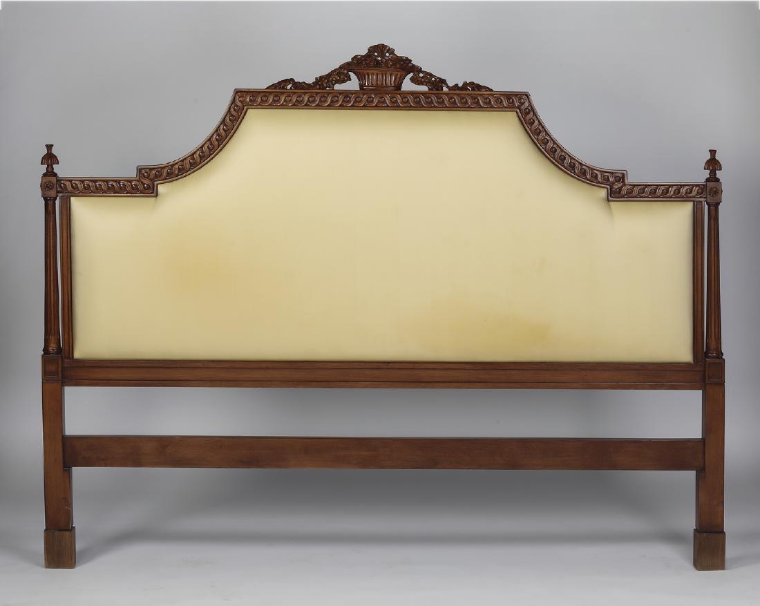 Neoclassical style carved & upholstered headboard: Neoclassical style upholstered headboard, having a carved basket of fruit crest surmounting a stylized arched frieze with a carved rinceau and padded cream upholstery, rising on fluted columnar suppor