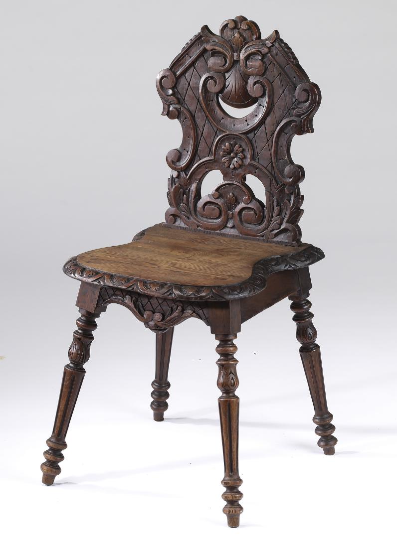 19th c. petite French carved oak hall chair: Petite French Renaissance Revival carved oak hall chair, late 19th century, having a pierce carved shaped back depicting scrolling acanthus above a shell on an incised trellis ground, centering a reli