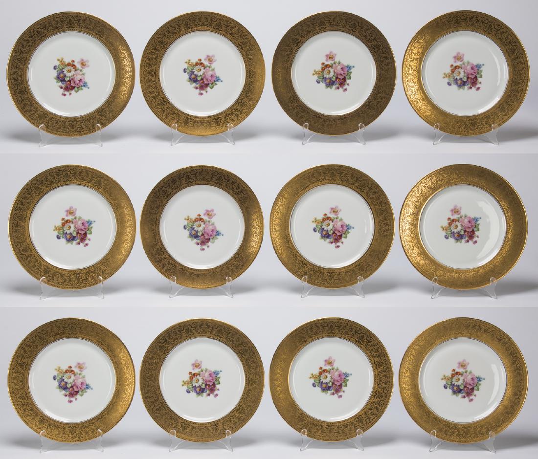 Set of 12 porcelain cabinet plates by Heinrich & Co.: Set of twelve porcelain cabinet plates, Heinrich & Co., each having an encrusted gold decoration of thin heart bands bordering a shell and scroll motif, centering a hand painted floral spray on white 