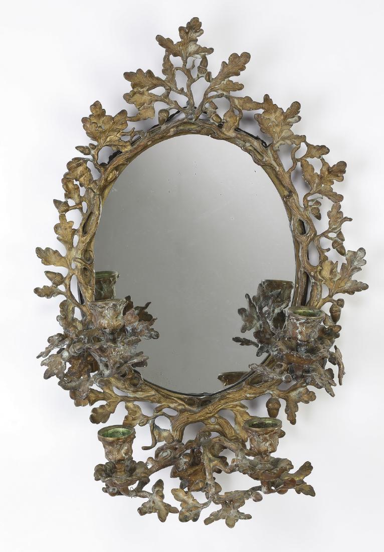 Gilt bronze oak leaf girandole wall mirror, 19"h: Gilt bronze girandole wall mirror, centering an oval mirror framed with gilt bronze oak leaves and acorns and terminating to four candelabra, mirror 10"h x 8"w; overall sise 19"h x 12.5"w x 7"d.