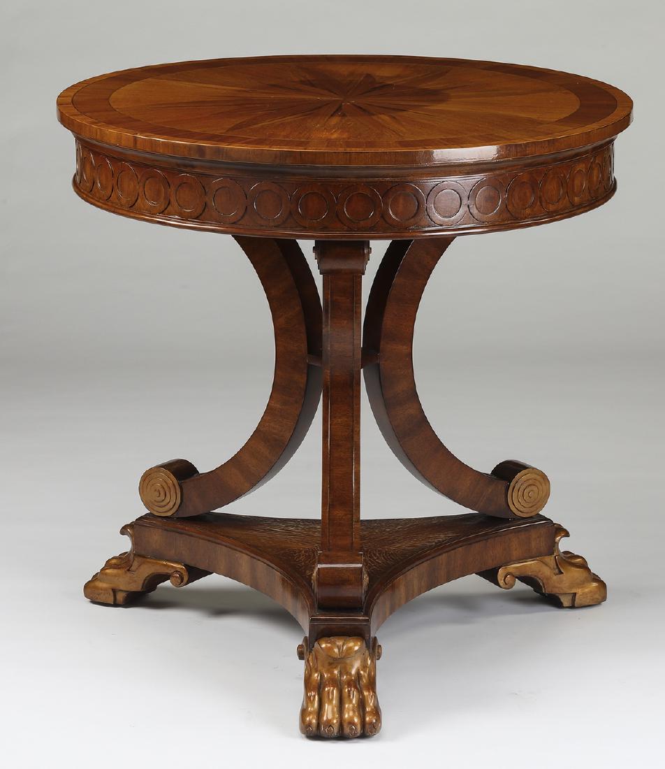 Maitland-Smith carved and gilt occasional table: Maitland-Smith carved mahogany occasional table, having a rosewood and satinwood sunburst and banded veneer surface, over the apron with carved rings, supported by three C-scroll legs with gilt feet,