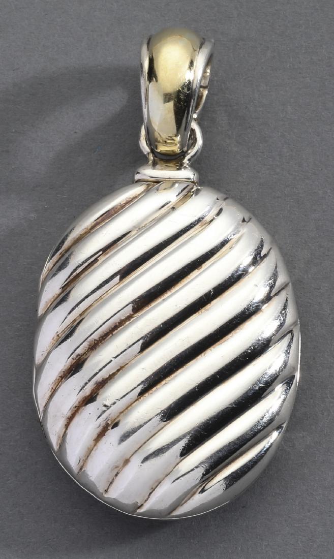 David Yurman 18k gold and sterling locket, 2.25"l: David Yurman 18k gold and sterling silver locket, of oval form with a large gold and silver enhancer bail, marked 750/.925 and David Yurman, 2.25"l x 1.20"w.