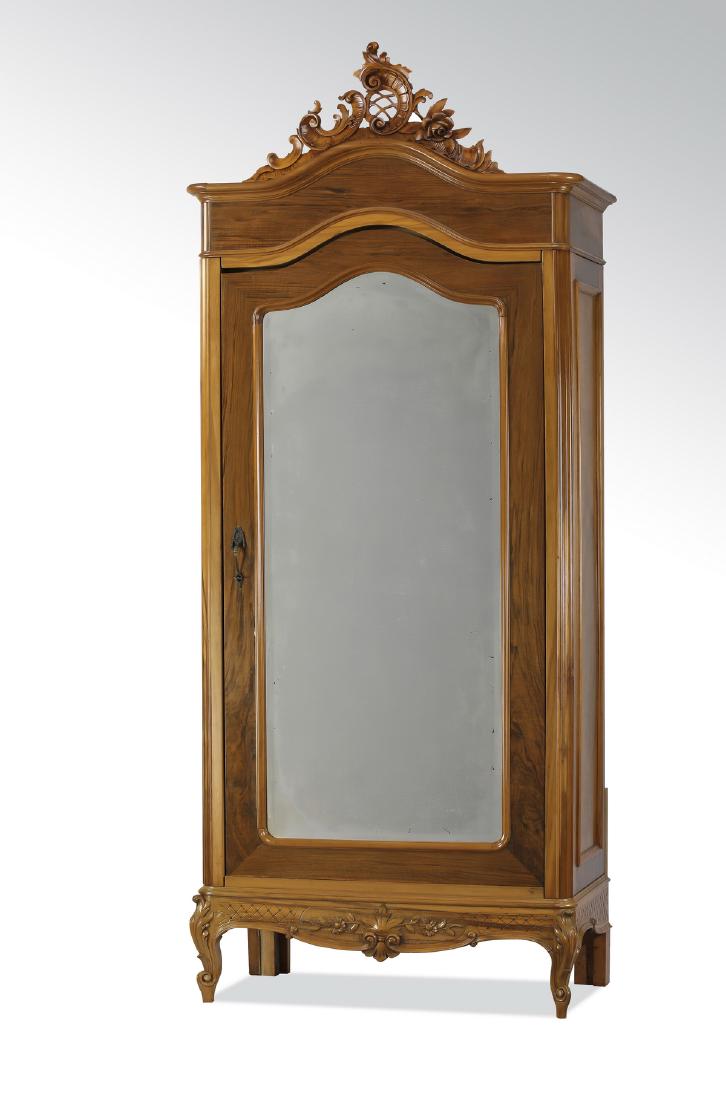 Rococo Revival style walnut mirrored armoire, 104"h: French Rococo Revival style walnut armoire, 19th century, having a pierced rocaille finial above an arched crest and wide frieze, surmounting a single door with a beveled mirror, opening to a shelf an