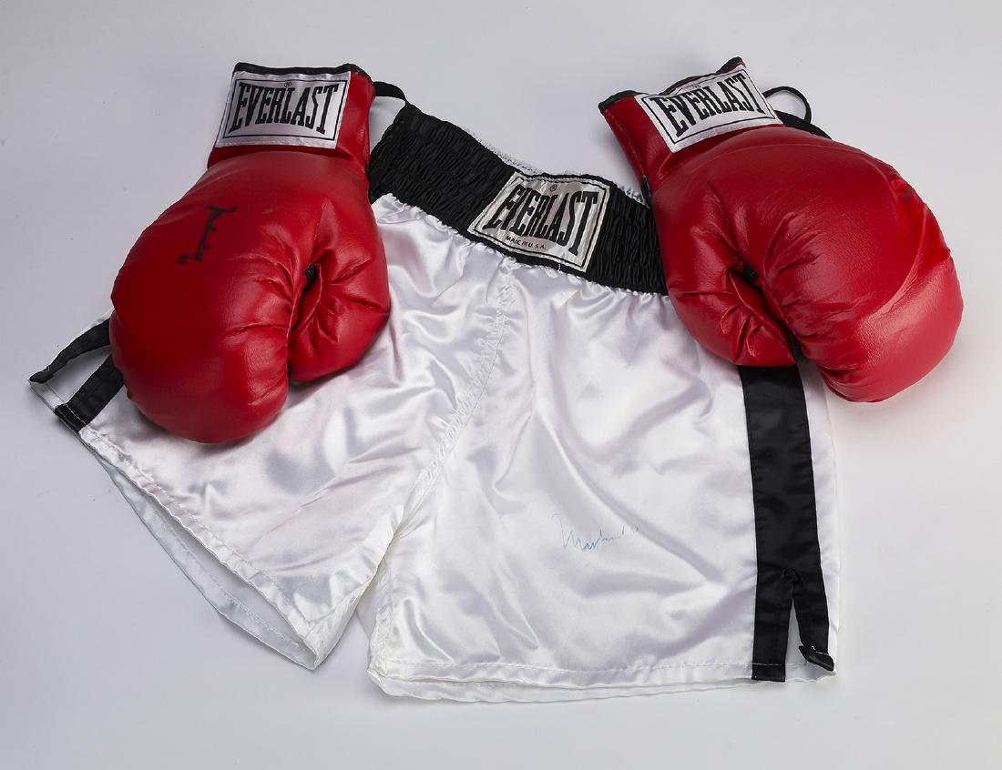 Muhammad Ali autographed boxing gloves and shorts: Muhammad Ali autographed leather boxing gloves and shorts, both by Everlast, the right glove bears the signature in black ink, 4.5"h x 12.5"w x 7.5"d, together with a pair of white boxing shorts havin