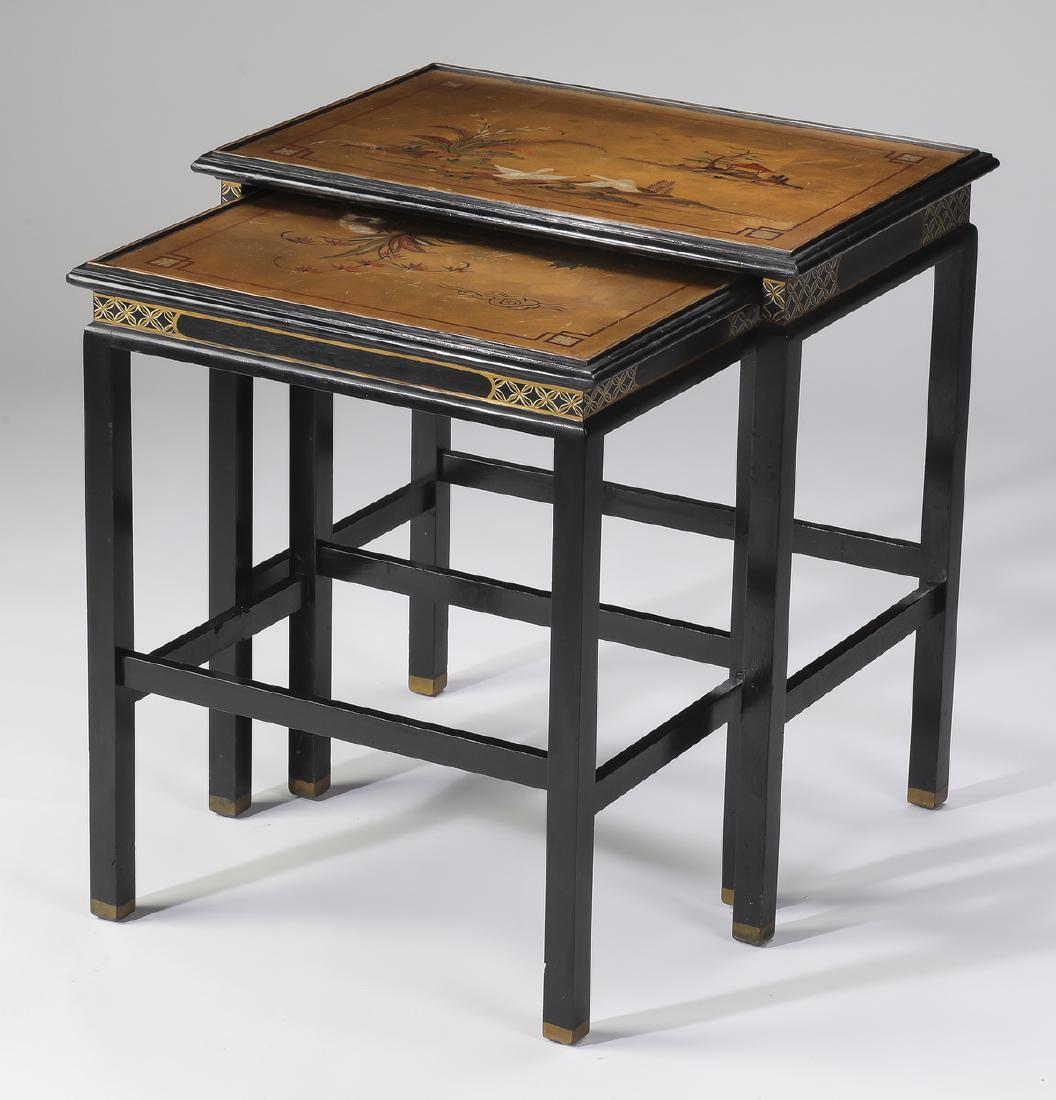 (2) Chinoiserie style hand painted nesting tables: Set of (2) Chinoiserie style gilded and paint decorated nesting tables, comprising: (1) tall ebonized table with a rectangular gilded top paint decorated with a landscape including swans and a pagoda,