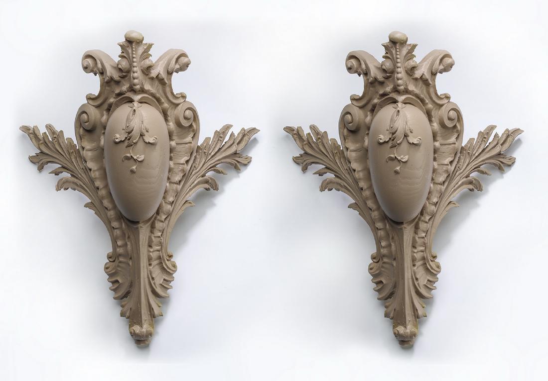 Pair of composite architectural cornerpieces, 21"h: Pair of architectural cornerpieces, each having elaborate acanthus scrollwork centering a carbachon accented with a leafy garland, each crafted of cast composite material, 21"h x 19"w x 12.25"d.