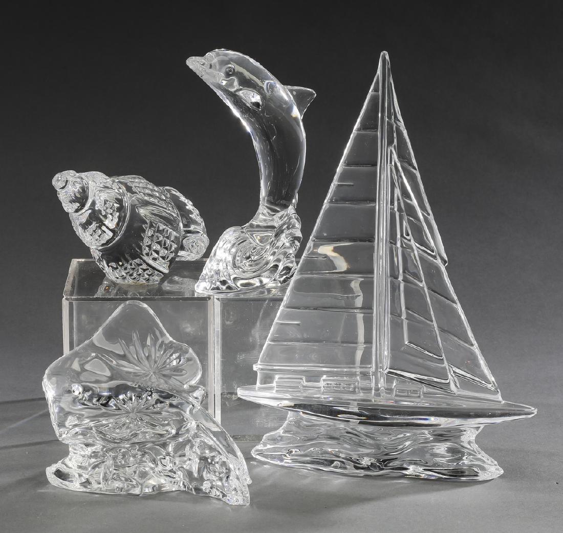 (4) Pcs. ocean themed crystal, (2) marked Waterford: Group of four ocean themed crystal pieces comprised of (1) a gliding stingray, marked 'Waterford" 3.5"h x 5"w x 4"d, (1) a jumping dolphin, marked 'Waterford,' 5.5"h x 3"w x 2.5"d, (1) a spiral seashe