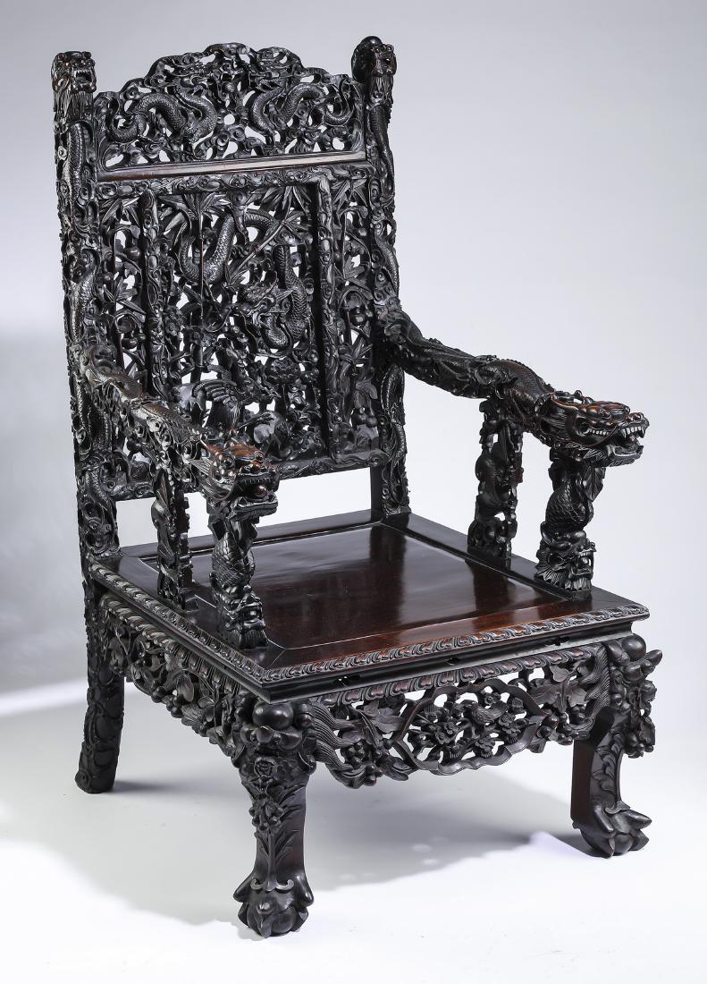 Rare 19th c. Chinese carved rosewood dragon chair: Rare 19th century Chinese carved dragon and phoenix rosewood throne chair, having an arched crest pierce carved with confronting dragons amidst auspicious cloud forms, flanked by dragon head finials, 