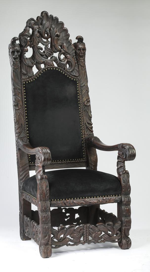 Carved mahogany throne chair upholstered in velvet: Carved mahogany throne chair, early 20th century, having a pierced crest with asymmetrically carved rocaille and acanthus scrolls, flanked by Green Man masks over carved stiles, centering a chapeau de