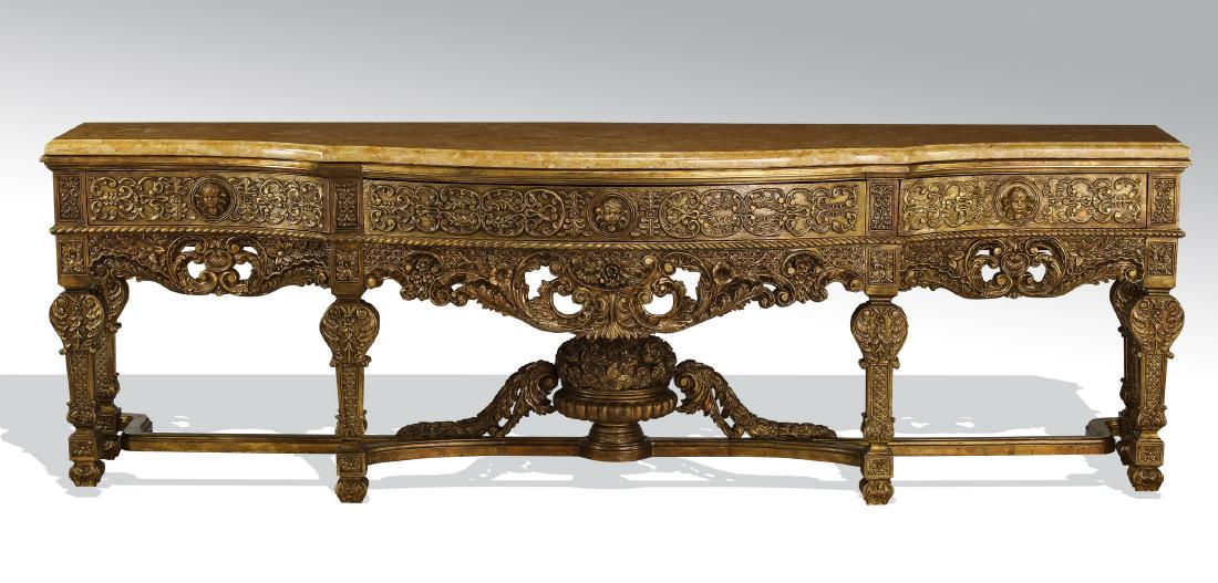 Monumental carved marble top console, 120"l: Monumental carved and parcel gilt console in the Renaissance Revival taste, having a buttercup yellow marble serpentine top with a molded edge above three foliate drawers with figural putti pulls, sur