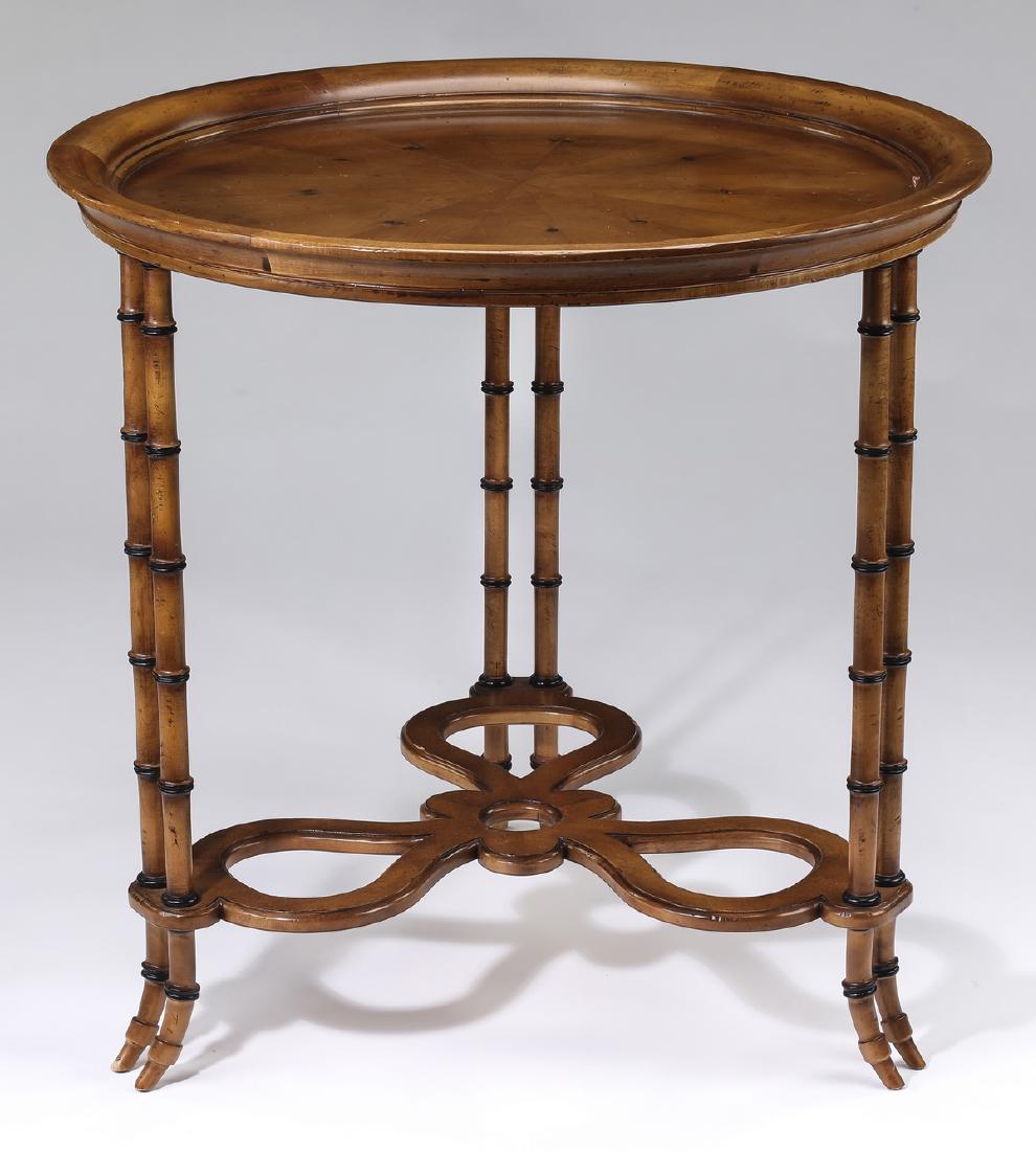 Baker Chinoiserie inspired faux bamboo side table: Baker Furniture Chinoiserie inspired faux bamboo side table, having a circular dished top with radial pattern, rising on three sets of twin column faux bamboo legs, joined by a sinuous pierced low str