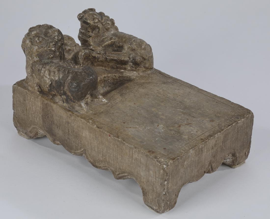 Japanese style figural Fu lion inkstone, 10"l: Japanese style figural carved inkstone, of rectangular form having a pair of Fu lions at one end, with a scalloped skirt, the whole rising on bracket feet, 5.75"h x 10.25"l x 6.75"d.