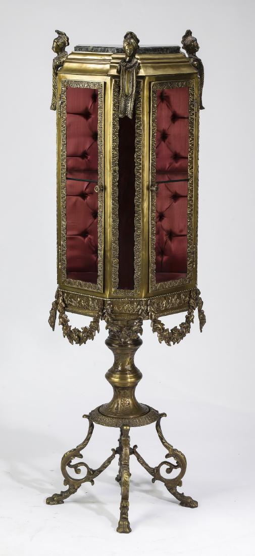 Brass curio cabinet, with Egyptian inspired figures: Egyptian inspired brass curio cabinet on stand, having a five sided marble top set into a molded cornice with three Egyptian style term figures, over a conforming brass and glass four pane cabinet, op