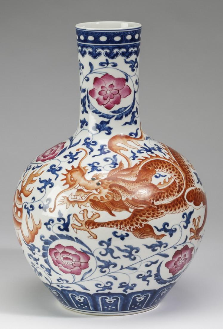 Chinese dragon vase, Qianlong mark, 12"h: Chinese blue and iron-red bottle vase, having a dotted band at the rim above a lingzhi band, the body decorated with a writhing five clawed dragon chasing a flaming pearl of wisdom amidst auspicious c