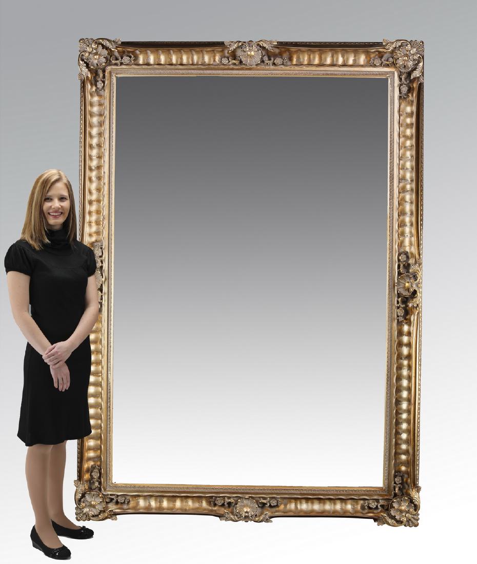 Monumental Rococo style gilt beveled mirror: Monumental Rococo style gilt-decorated beveled glass mirror, of cast composite material, having scallop cartouche accents to the gilt-decorated frame, centering the beveled glass, 84"h x 59"w x 5"d.