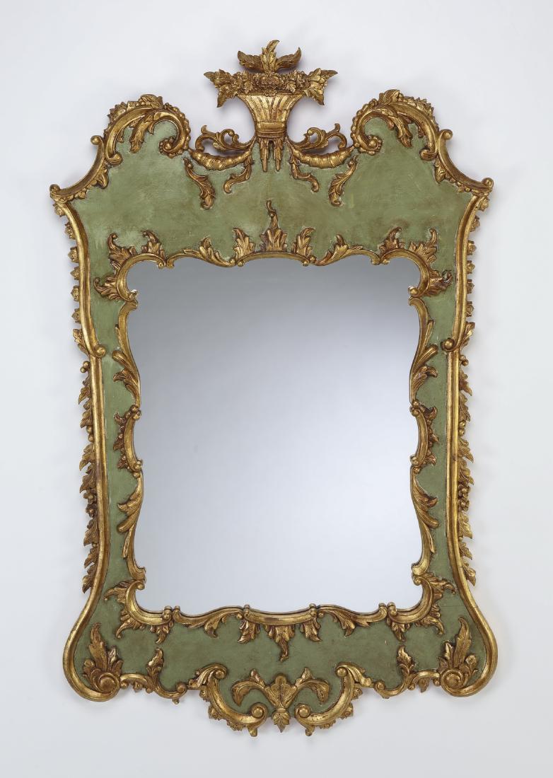 Gilt and paint decorated Rococo style mirror, 56"h: Giltwood and paint decorated mirror in the Rococo taste, having a carved flower basket crest over a shaped mirror, ornamented throughout with gilt scrolling foliage on a paint decorated ground; mirror