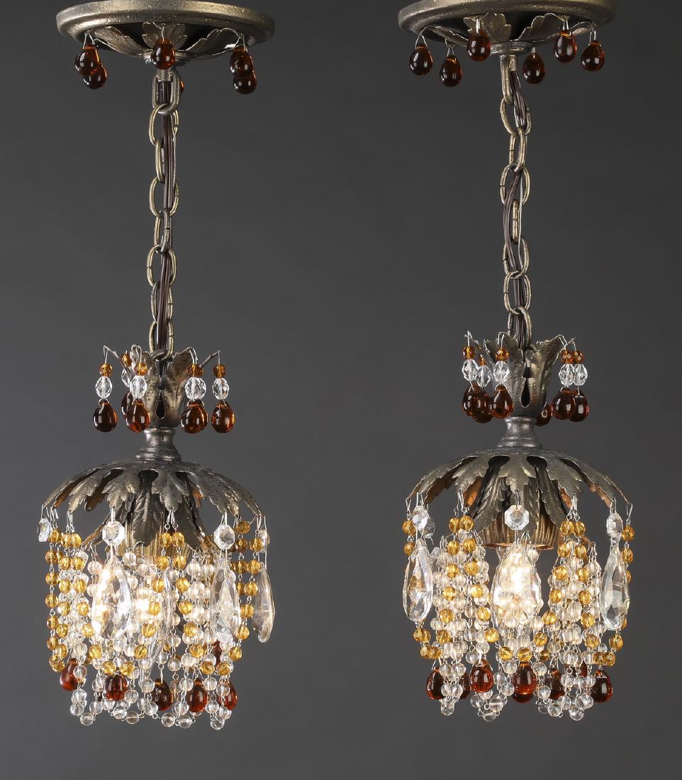 (2) Contemporary glass bead & crystal pendant lights: Pair of contemporary glass bead and crystal pendant lights, each having a circular ceiling mount hung with amber bead drops, hanging the foliate form crown hung with amber and clear bead strands, abov