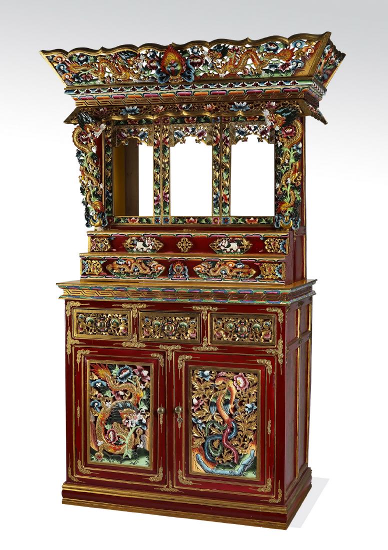 Tibetan carved and paint decorated altar cabinet: Tibetan carved and paint decorated Chosham or altar cabinet, having a pierce carved crown, centering the 'Cintama?i' or wish granting gem, flanked by writhing dragons, lotus flowers, and auspicious cl
