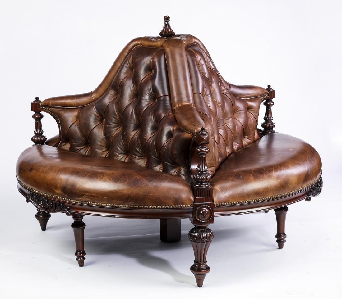 Maitland-Smith button-tufted leather borne settee: Maitland-Smith button-tufted leather and mahogany borne settee, having a reeded finial surmounting the circular settee, divided into three sections by sloping arms terminating in turned and reeded sti