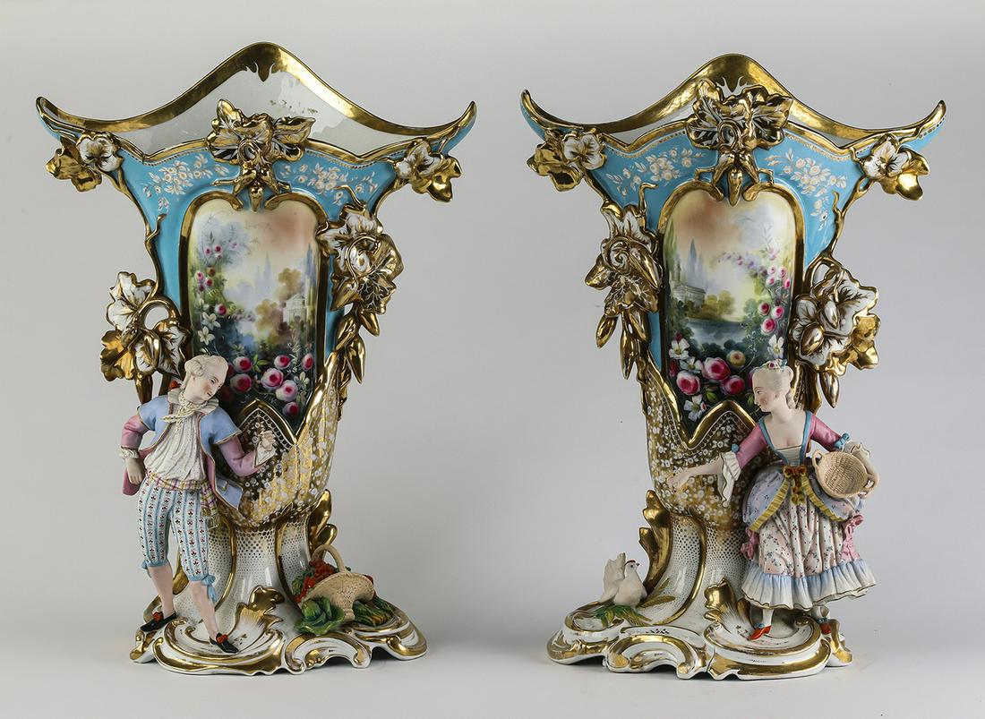 (2) Rococo style porcelain and bisque vases, 22"h: Pair of Rococo style porcelain and bisque vases, each of trumpeted form, having a gilt-decorated rim accented with dimensional leaves, above the tapering body having a painted garden landscape framed 