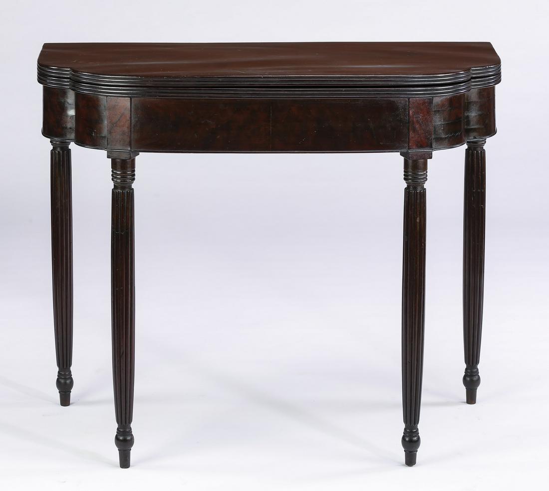 19th c. mahogany Sheraton gate leg card table: Mahogany gate leg card table in the Sheraton taste, 19th century, having a double D-shaped top with reeded edges, over a cockbeaded apron rising on swelling round reeded legs terminating to toupie fee