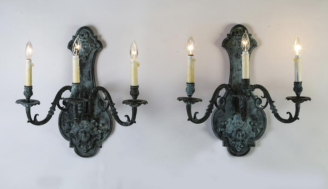 Pair of 3-light Renaissance sconces with Medusa heads: Pair of patinated bronze 3-light sconces in the Renaissance taste, having a shaped wall plaque decorated with Medusa heads, each issuing three foliate arms terminating to faux candles, 21"h x 20"w x 1