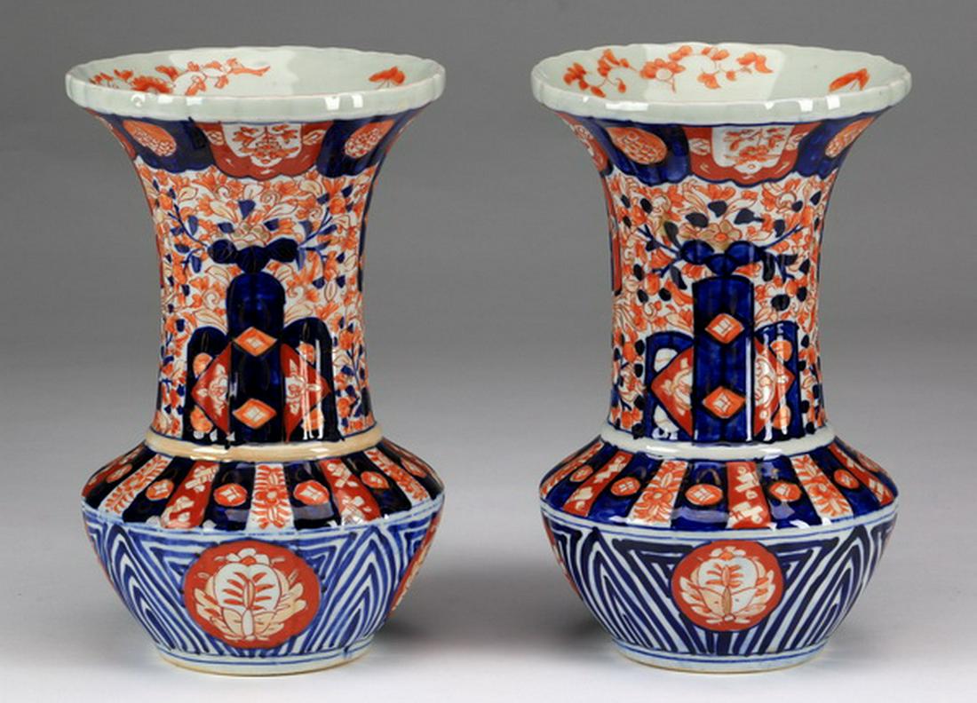 (2) Japanese Imari porcelain vases, 19th c.: Pair of Japanese Imari porcelain vases, Meiji period, of fluted form with flared rims, cylinder necks, and bulbous bodies, the rim decorated with images of auspicious objects, the necks with floral de