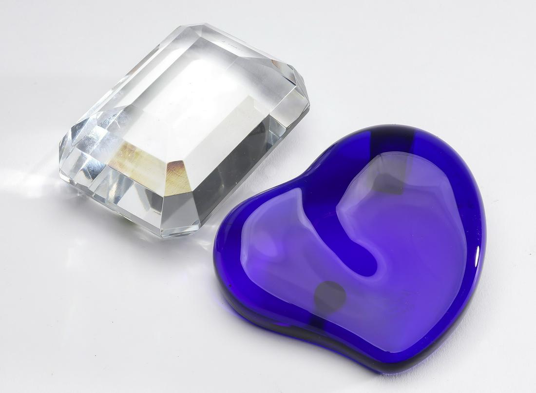 (2) Tiffany glass paper weights incld. Elsa Peretti: Two Tiffany glass paper weights, comprising an Elsa Peretti cobalt heart, maker marked and retaining the original Tiffany paper label, 4"h x 3.5"w x .50"d; together with a step cut clear glass example