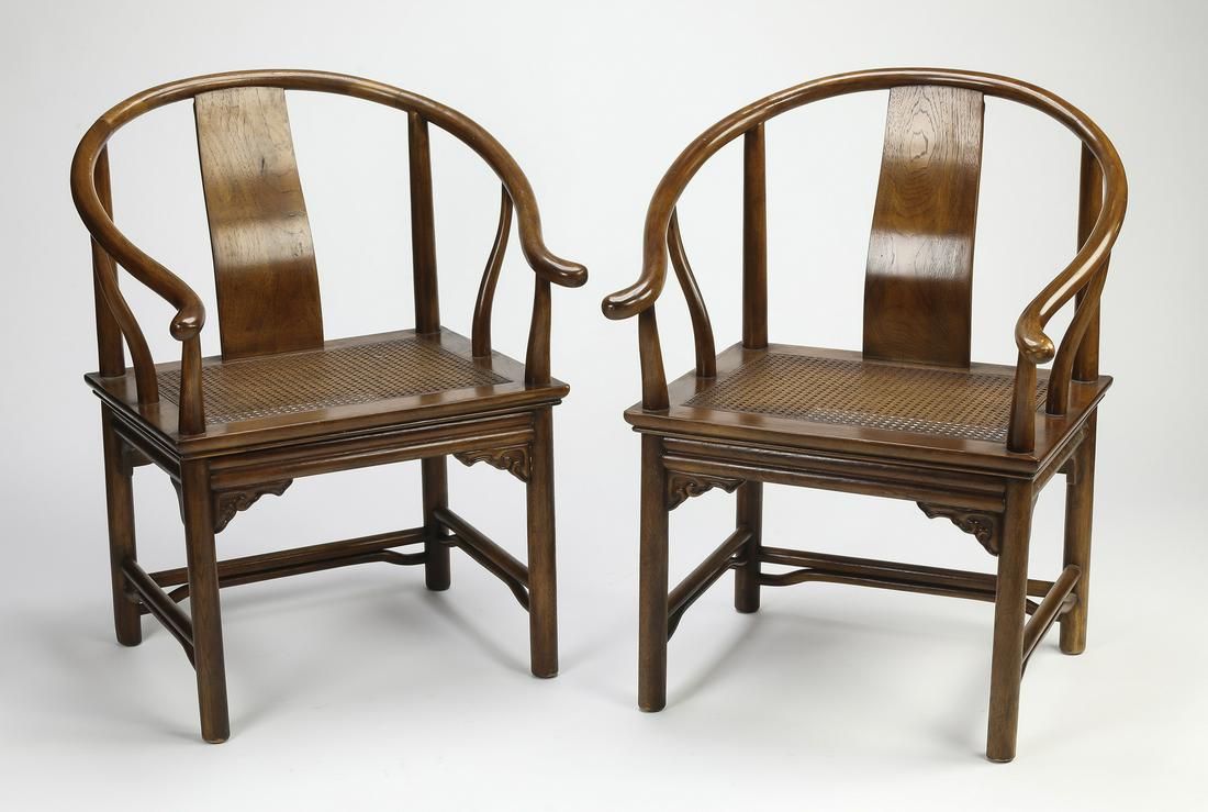 (2) Chinese hardwood horseshoe chairs w/ caned seats: Pair of Chinese hardwood horseshoe chairs, each having a continuous arm terminating to outswept hand rests, above a square caned seat and a rounded apron over lingzhi spandrels, rising on round legs j