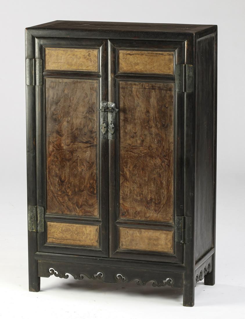 Chinese ebonized hardwood and burl cabinet, 40"h: Diminutive Chinese ebonized hardwood and burl cabinet, having a rectangular top surmounting two doors, each inset with burl panels, opening to one shelf and two drawers, above a skirt carved with ling