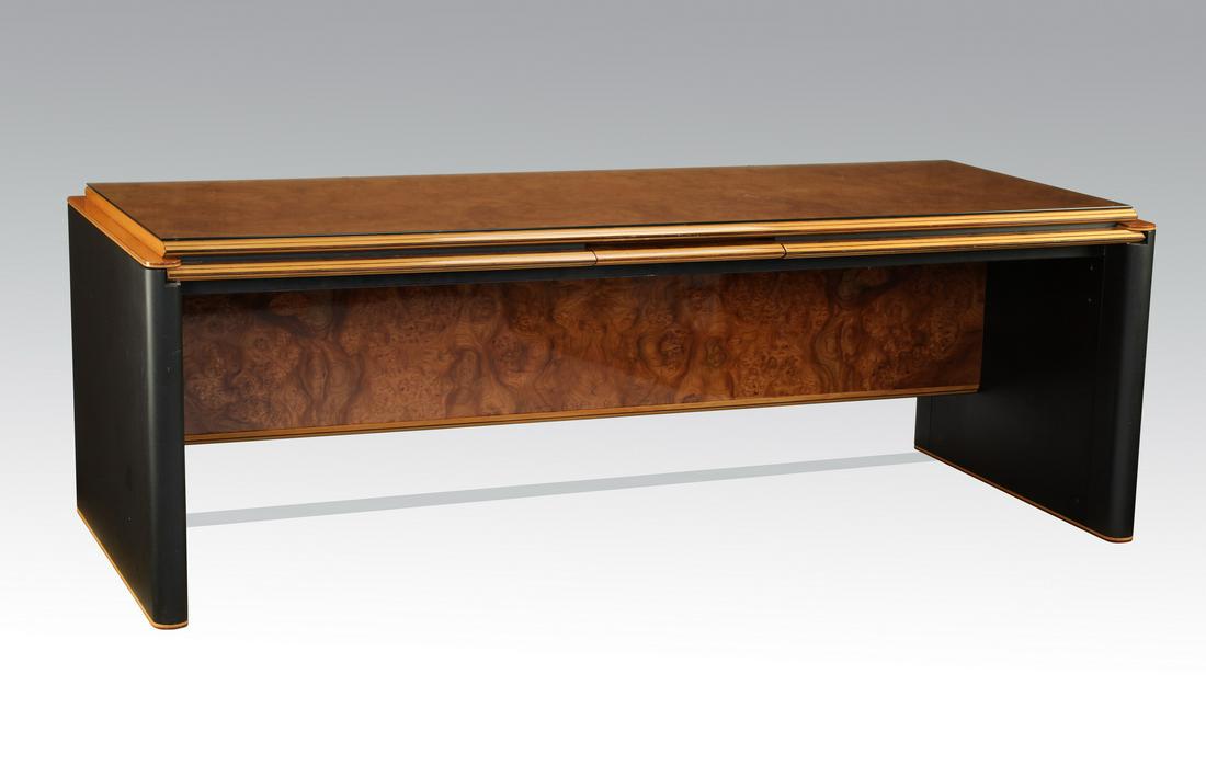 Italian bookmatched burl executive desk, 87"l: Contemporary Italian burl and ebonized wood executive desk, having a rectangular burl top with a glass topper, resting on a knife edge apron with a central frieze drawer, the whole rising on matte bla