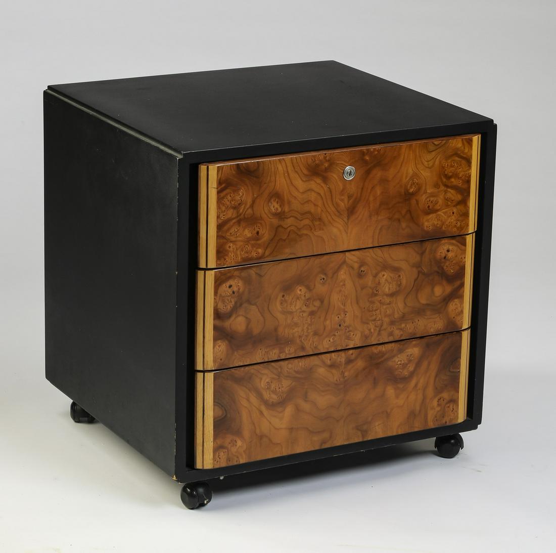 Italian burl and ebonized wood rolling cabinet, 23"h: Italian burl and ebonized wood rolling cabinet, having a square ebonized wood top with waterfall sides, fronted by three burl drawers, the whole rising on casters, 23"h x 23"w x 21.5"d.
