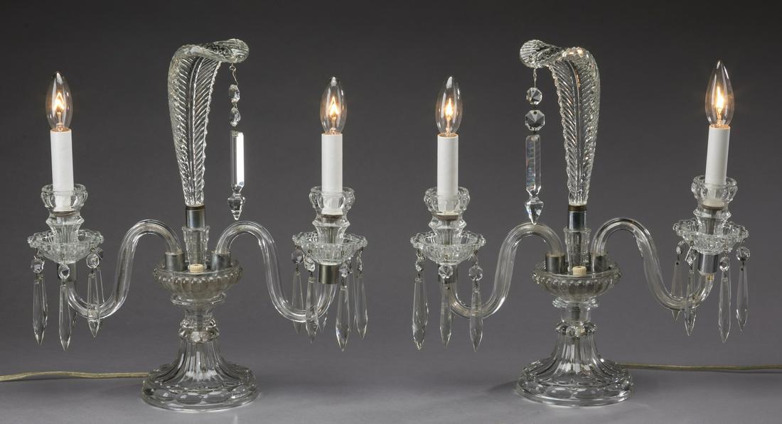 (2) Art Deco style glass candelabra lamps, 14"h: Pair of Art Deco style glass candelabra lamps, each having a feather form finial resting on a fluted urn, issuing two 'S' curve arms hung with prisms and swags, rising on a knopped standard, and resti