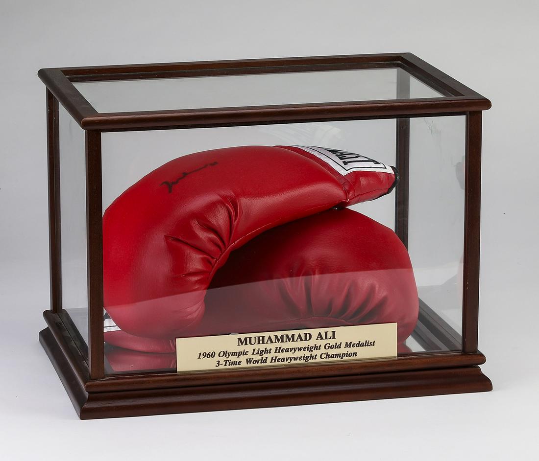 Muhammad Ali autographed boxing gloves with case: Muhammad Ali autographed leather Everlast boxing gloves, the right glove bears the signature in black ink, 5.25"h x 12.25"w x 7"d, together with a wood and glass vitrine having a mirrored bottom and a