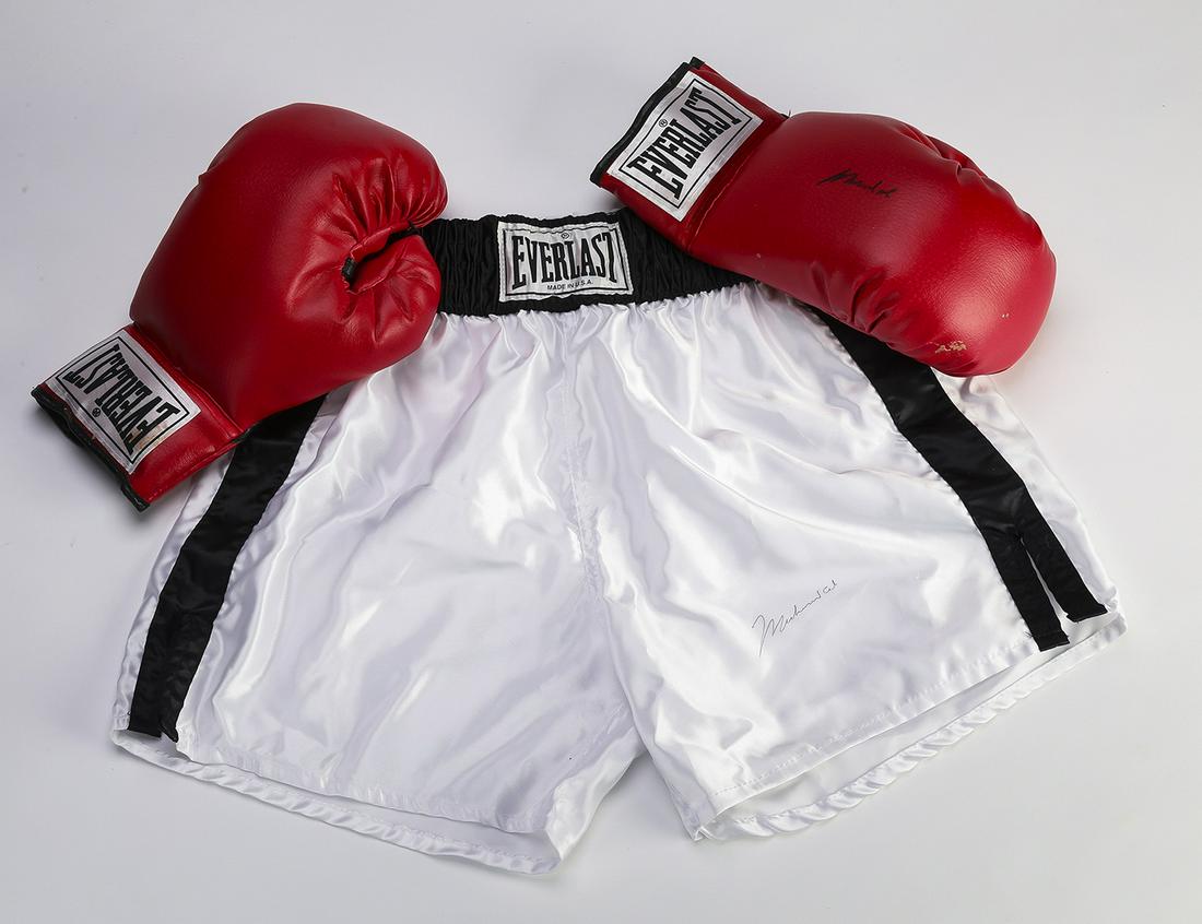 Muhammad Ali autographed boxing gloves and shorts: Muhammad Ali autographed leather boxing gloves and shorts, both by Everlast, the right glove bears the signature in black ink, 5"h x 12.5"w x 7"d, together with a pair of white boxing shorts having a