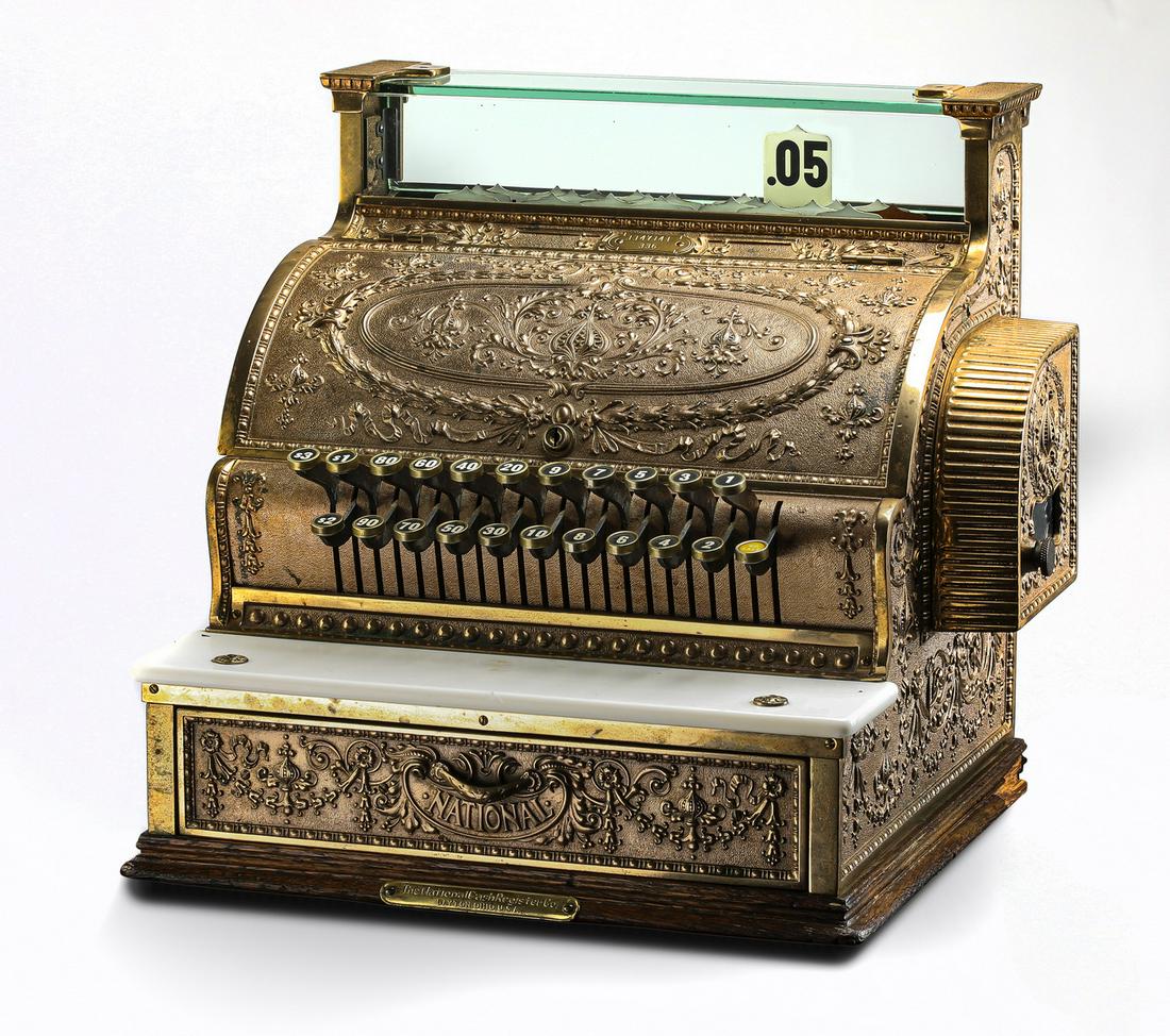 1912 brass National Cash Register Model 336, 17"h: National Cash Register Model 336, 1912, serial number 1147141, executed in brass in all-over dolphin design, with a side receipt cage, the maker's mark inscribed to the base plate, the whole rising on