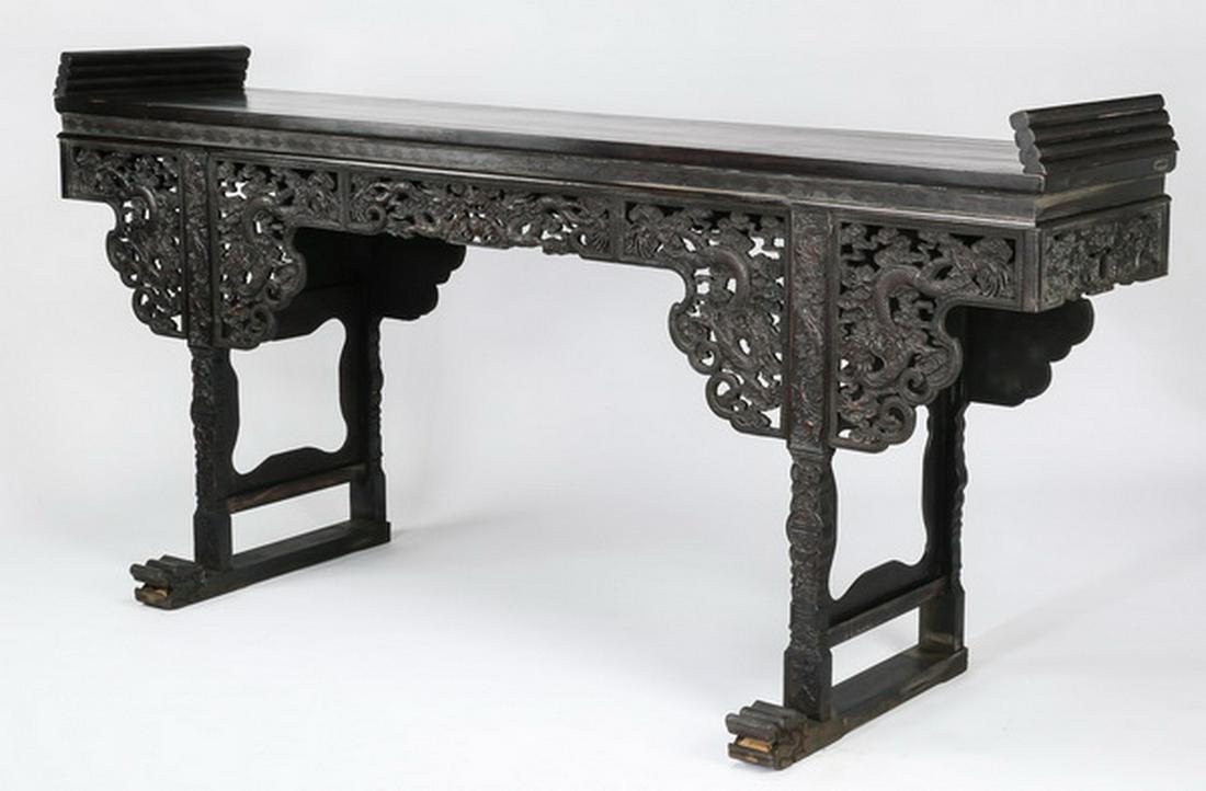 Monumental Chinese carved dragon & cloud altar table: Large and impressive Chinese carved dragon and cloud altar table, having a floating panel top with exaggerated upturned flanges, above a recessed relief carved leiwen band, and an apron heavily carved